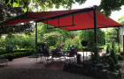 Image of syncra system fitted with  cassetted folding-arm awnings in cafe beer garden.>