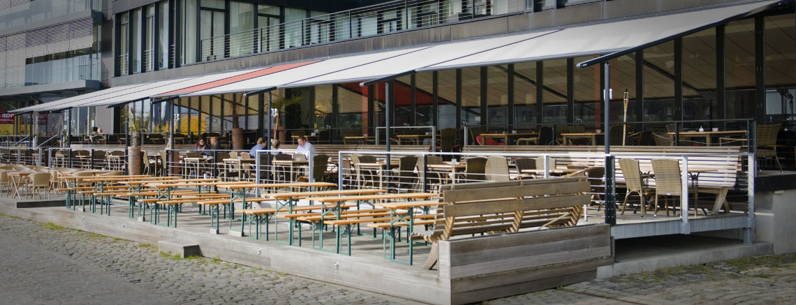 Image of coupled pergolas covering seating area outside restaurant